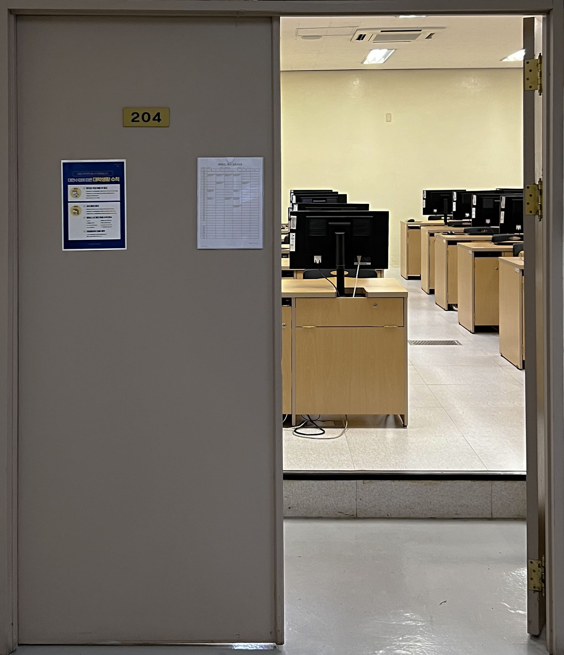 회색빛이 도는 짙은 베이지색의 철제문이다. 왼쪽 문은 닫혀있고 오른쪽 문은 열려있다.